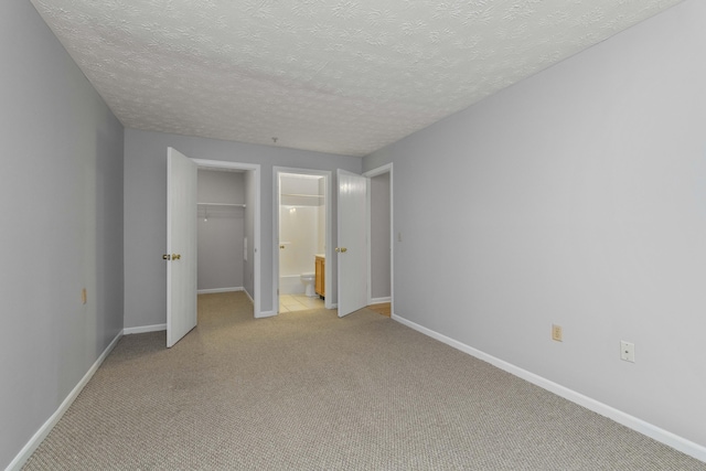 1081 S Broadway Unit 104, Lexington, KY 40504 - unfurnished bedroom with light carpet, ensuite bath, a closet, baseboards, and a textured ceiling