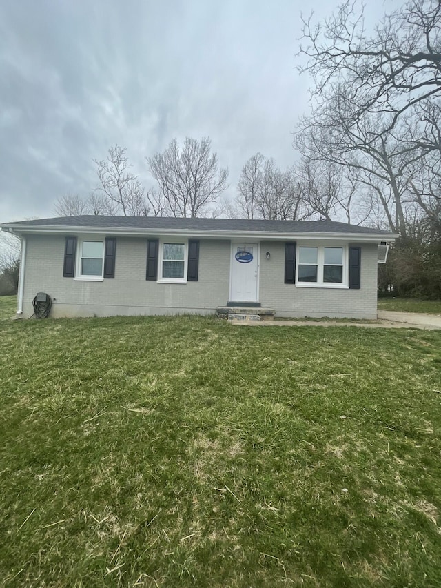 single story home featuring entry steps, a front lawn, and brick siding