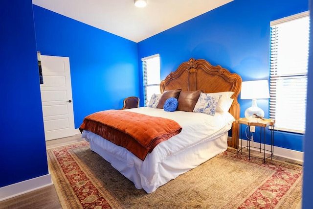 bedroom featuring baseboards and wood finished floors