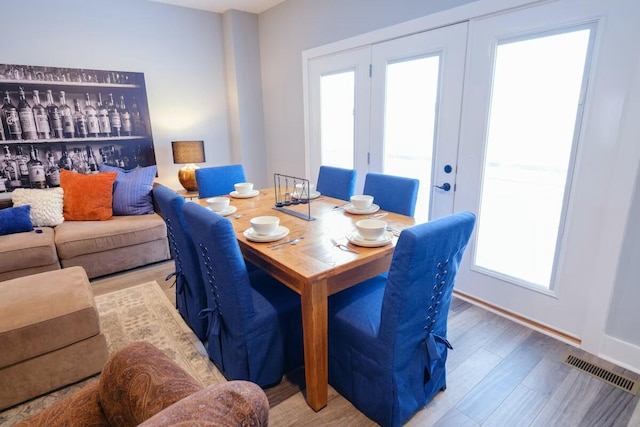 dining area with baseboards, wood finished floors, and visible vents