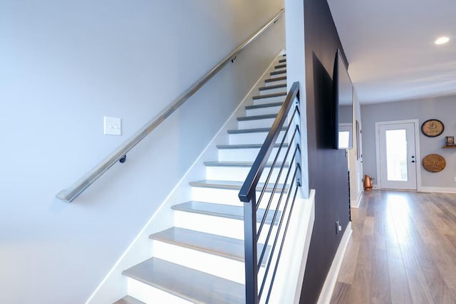 stairway with baseboards, recessed lighting, and wood finished floors