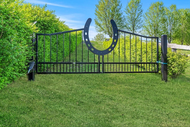 view of gate with a lawn