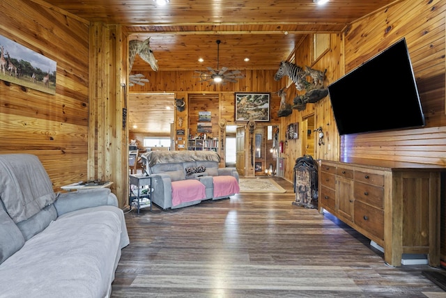 living room with wood walls, ceiling fan, wood finished floors, and wooden ceiling