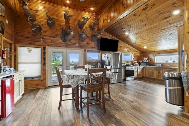 dining room featuring a healthy amount of sunlight, wood ceiling, wood walls, and wood finished floors