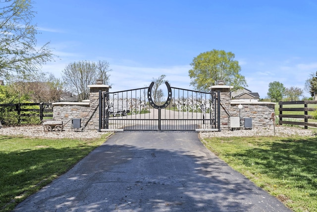 view of gate featuring fence and a yard