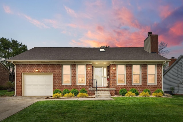 single story home featuring a front yard, a chimney, brick siding, an attached garage, and driveway