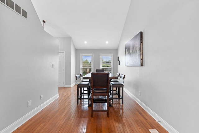 dining room with baseboards, visible vents, and hardwood / wood-style flooring