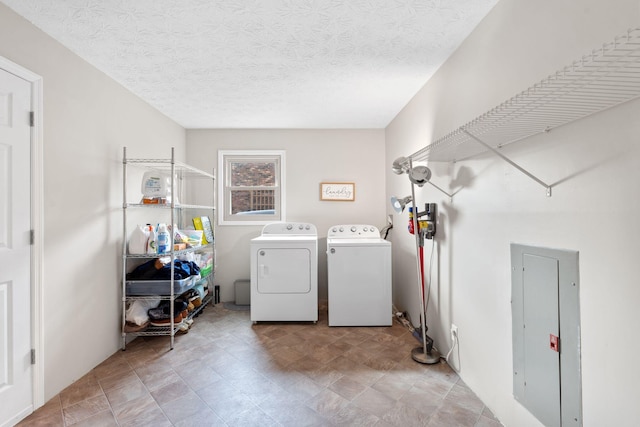 clothes washing area with laundry area, a textured ceiling, and washer and dryer
