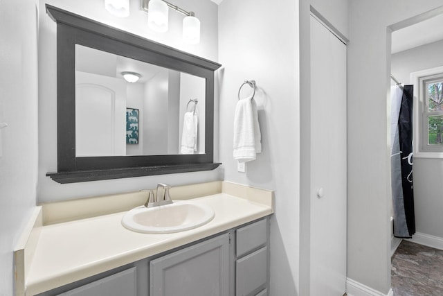 bathroom with a shower with curtain, baseboards, and vanity