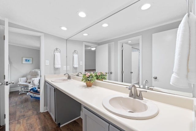 bathroom featuring recessed lighting, a sink, and wood finished floors