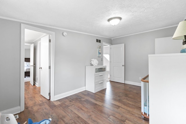 interior space with crown molding, dark wood-style flooring, baseboards, and visible vents