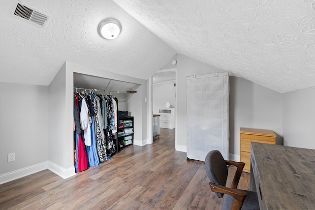 office area with a textured ceiling, visible vents, and wood finished floors