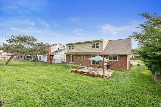 rear view of house with a patio, a fenced backyard, brick siding, a shingled roof, and a yard