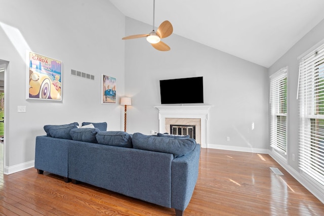 living area with a premium fireplace, ceiling fan, hardwood / wood-style flooring, and visible vents