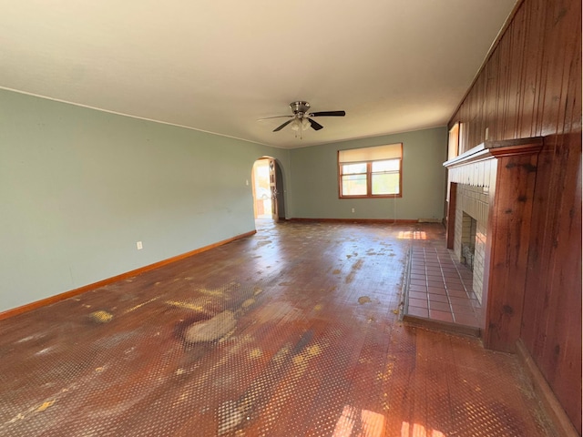 1312 Roosevelt St, Corbin, KY 40701 - unfurnished living room featuring ceiling fan, arched walkways, baseboards, wood finished floors, and a tile fireplace
