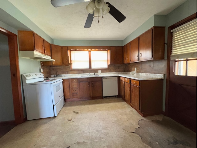 1312 Roosevelt St, Corbin, KY 40701 - kitchen with brown cabinetry, under cabinet range hood, a healthy amount of sunlight, and white appliances
