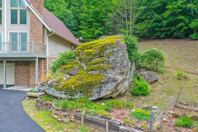 832 Cliffs Edge Rd, East Bernstadt, KY 40729 - view of property exterior featuring a chimney, a balcony, an attached garage, driveway, and brick siding