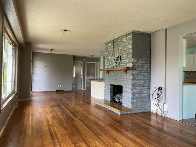 unfurnished living room featuring wood finished floors, a textured ceiling, and a fireplace