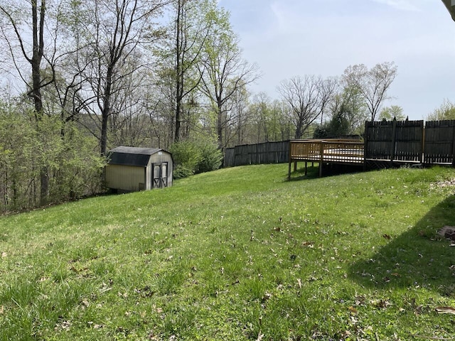 view of yard featuring fence, an outbuilding, and a storage shed