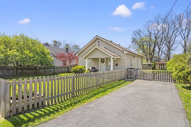 view of front of property with a gate, a front yard, and a fenced front yard