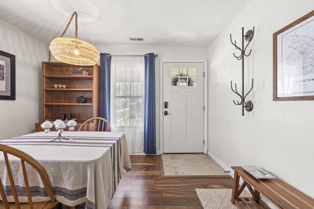 dining area featuring wood finished floors, visible vents, and baseboards