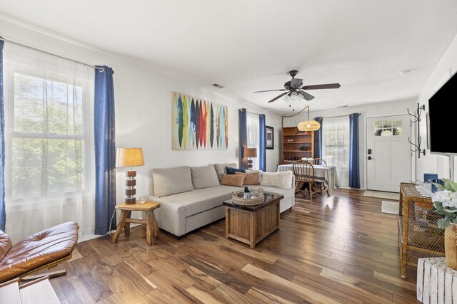 living room featuring ceiling fan, wood finished floors, and visible vents