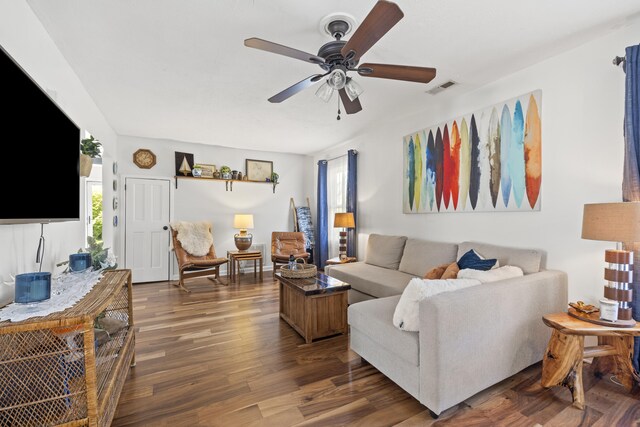living room with wood finished floors, visible vents, and ceiling fan
