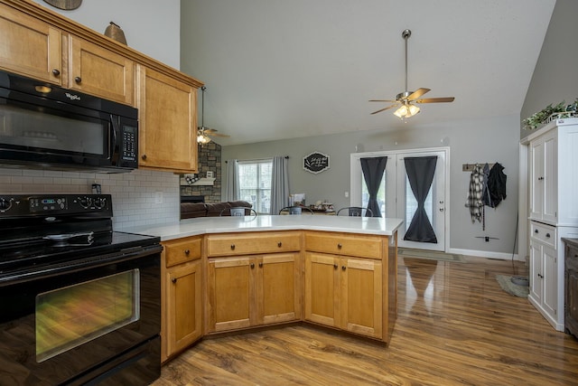 kitchen featuring black appliances, a ceiling fan, a peninsula, and lofted ceiling