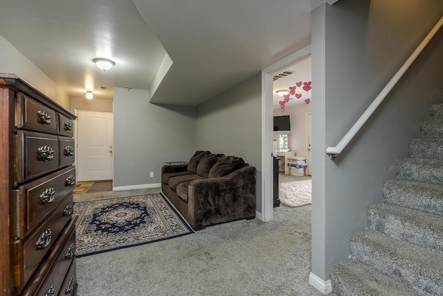 carpeted living room featuring stairway, visible vents, and baseboards