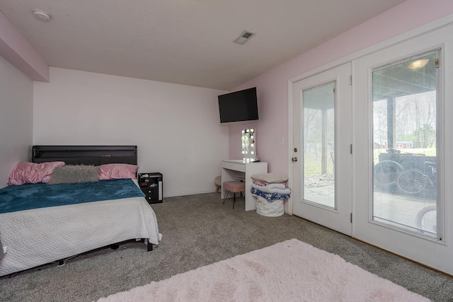 carpeted bedroom featuring baseboards, visible vents, and access to exterior