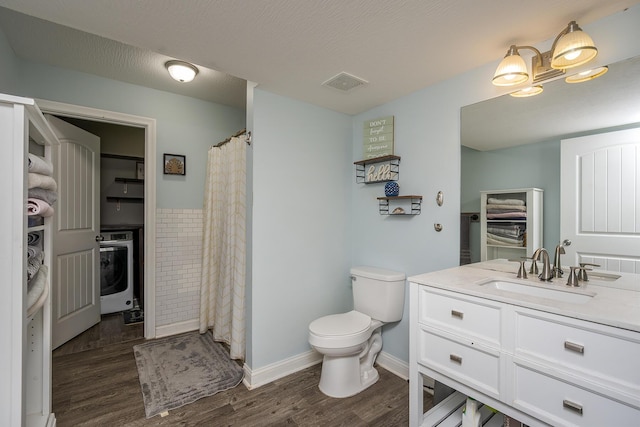 bathroom with vanity, toilet, visible vents, washer / clothes dryer, and wood finished floors