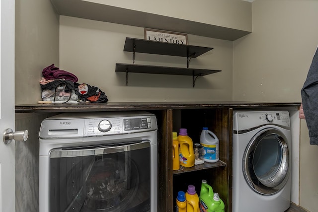 clothes washing area with washer and clothes dryer and laundry area