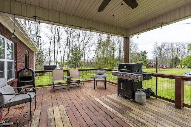 wooden deck with a lawn and ceiling fan