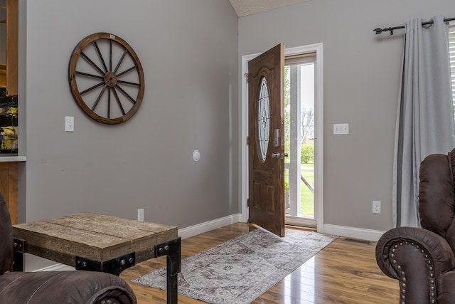 foyer entrance with wood finished floors, visible vents, and baseboards
