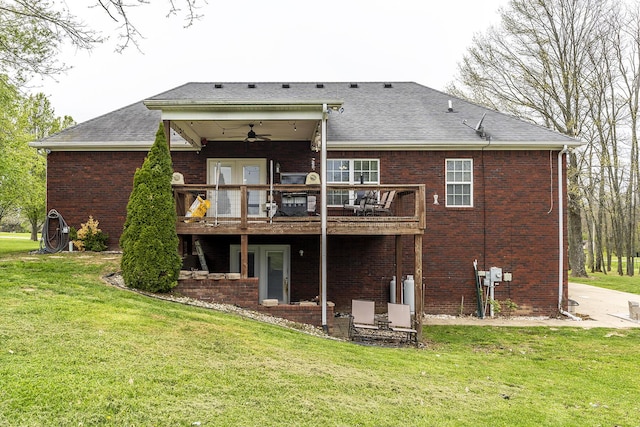 back of house featuring a wooden deck, brick siding, a yard, ceiling fan, and roof with shingles