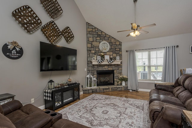 living room featuring wood finished floors, vaulted ceiling, ceiling fan, a fireplace, and baseboards