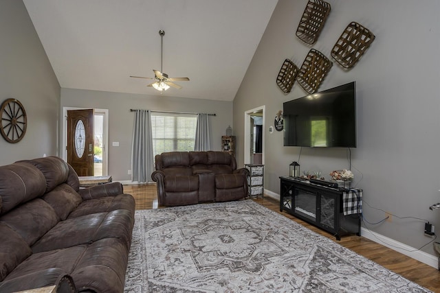 living area with wood finished floors, a ceiling fan, high vaulted ceiling, and baseboards