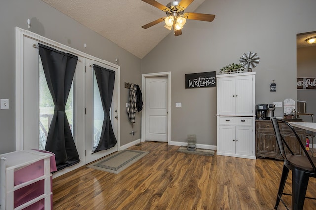 interior space featuring wood finished floors, ceiling fan, vaulted ceiling, and baseboards