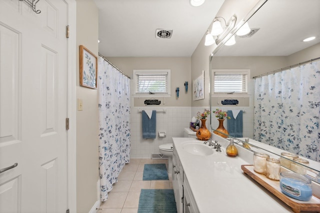 full bath with tile patterned flooring, a wealth of natural light, toilet, and vanity