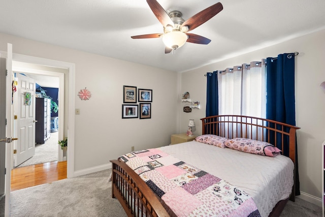 bedroom with baseboards, ceiling fan, and light carpet