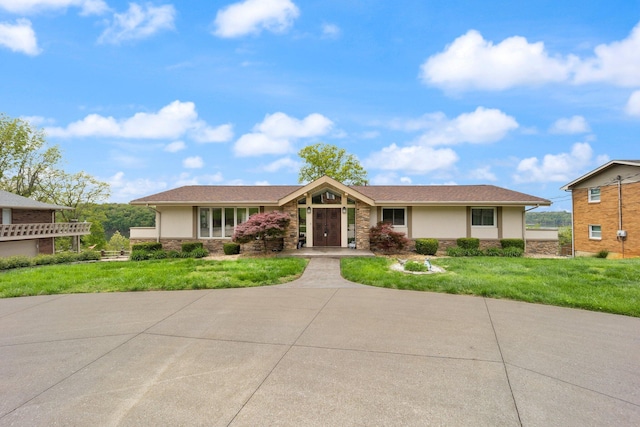 ranch-style house with a front lawn, stucco siding, and stone siding