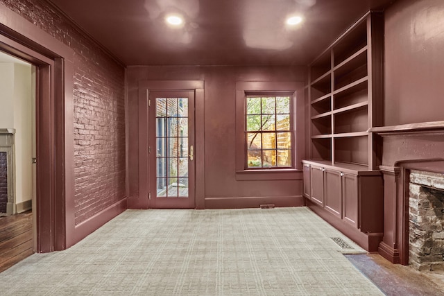 doorway with recessed lighting, carpet floors, visible vents, and a fireplace