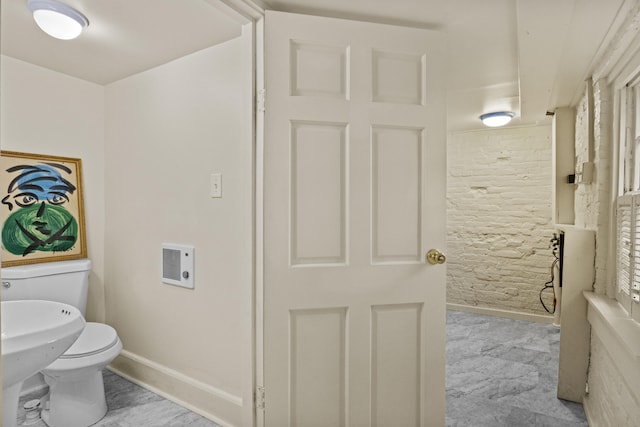 bathroom with toilet, heating unit, and baseboards
