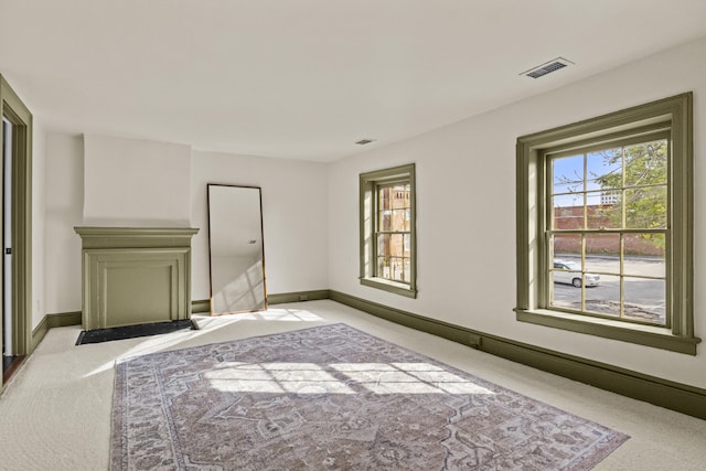 empty room with visible vents, baseboards, and light carpet
