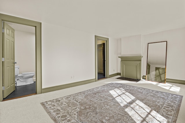 interior space featuring baseboards, carpet floors, and connected bathroom