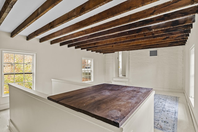 interior space featuring a wealth of natural light, beamed ceiling, and visible vents