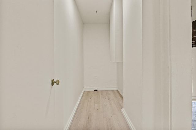 hallway featuring baseboards and light wood-type flooring