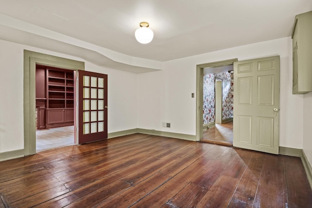 spare room featuring baseboards, french doors, hardwood / wood-style floors, and visible vents