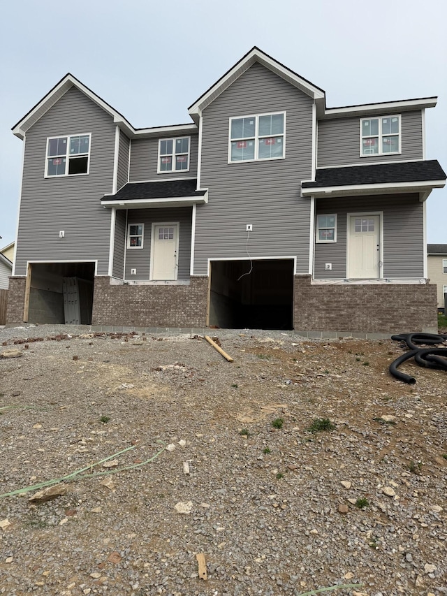 view of front facade featuring brick siding and a garage