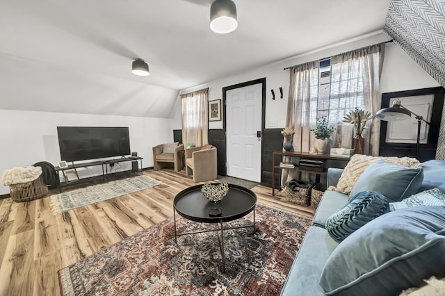 living area with vaulted ceiling and wood finished floors